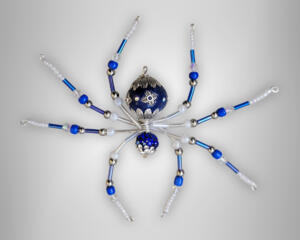 Blue and white beaded wire spider featuring glass beads, silver metal accents, and an ornate focal bead for magical winter-inspired décor.